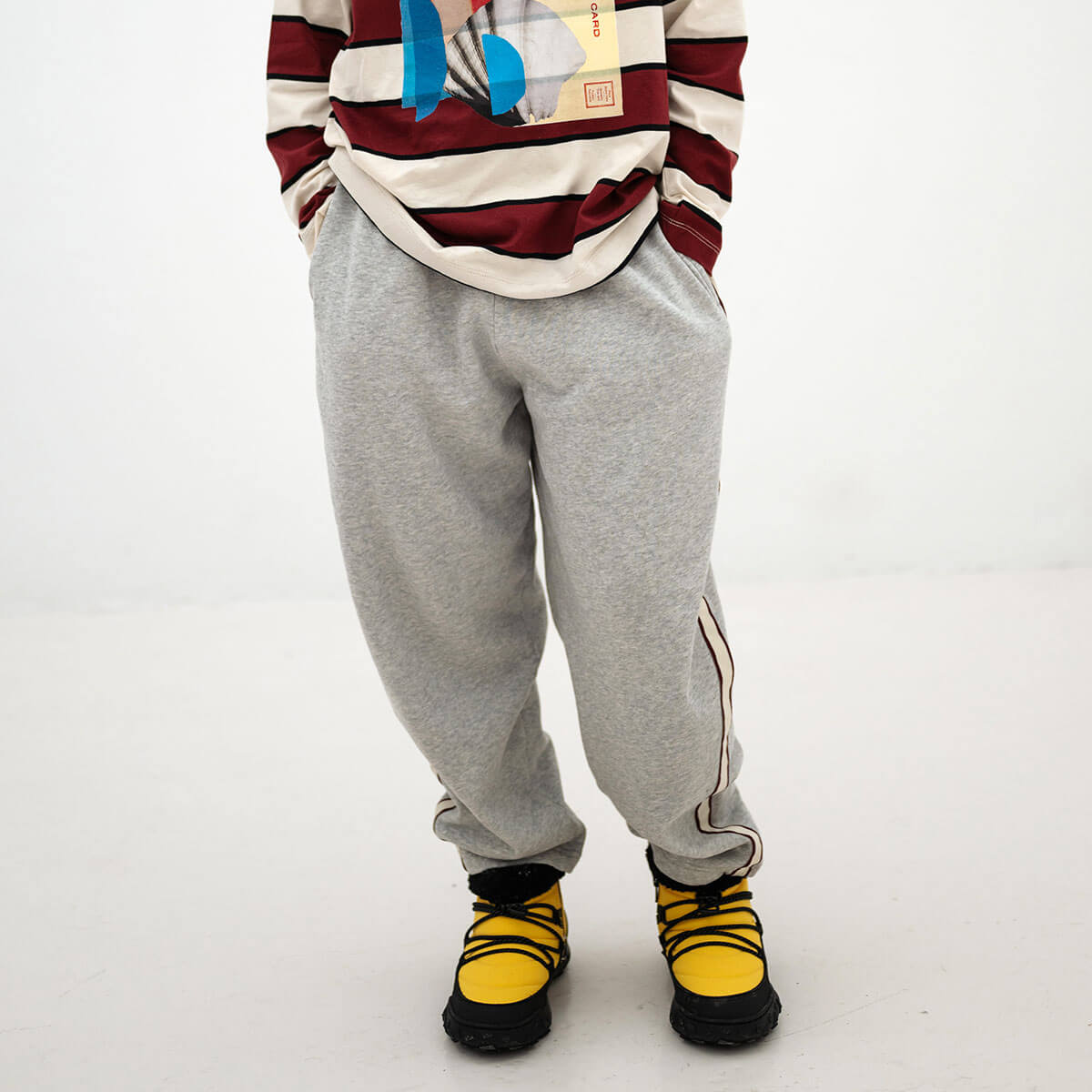 Pantalon de jogging ballon sportif gris clair chiné en coton biologique avec rayures latérales contrastantes et longueur 7/8 pour enfants de 2 à 14 ans