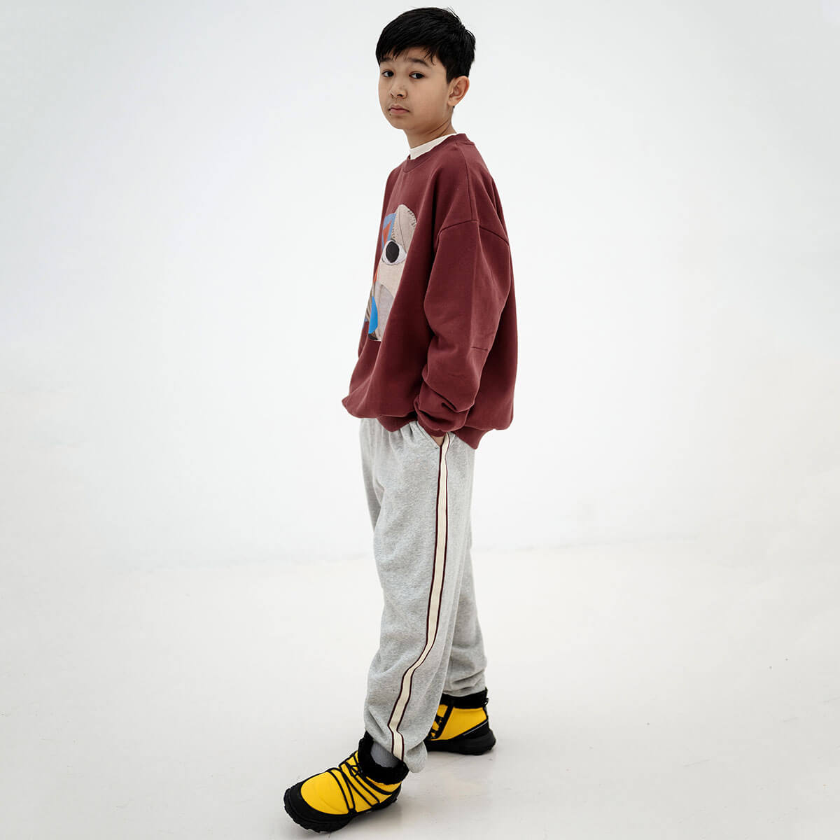 Pantalon de jogging ballon sportif gris clair chiné en coton biologique avec rayures latérales contrastantes et longueur 7/8 pour enfants de 2 à 14 ans